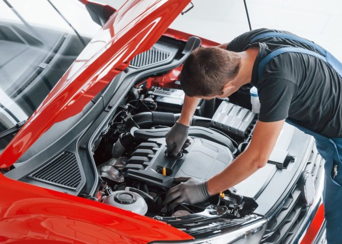 top-view-of-male-worker-in-uniform-that-repairs-red-automobile.jpg